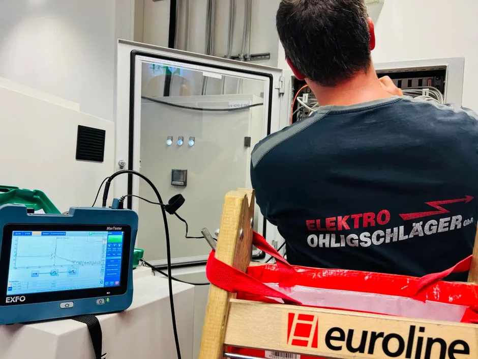 Monteur von Elektro Ohligschläger bei Messarbeiten an einer Glasfaseranlage